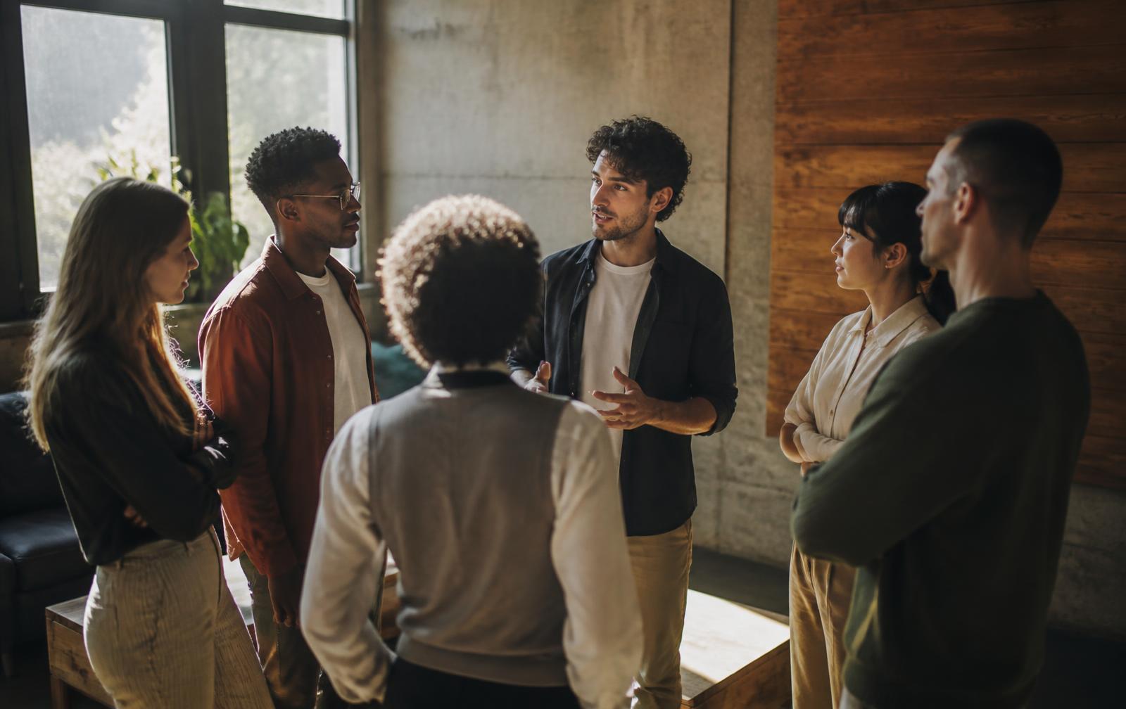 A small team standing in a circle during a morning campaign briefing